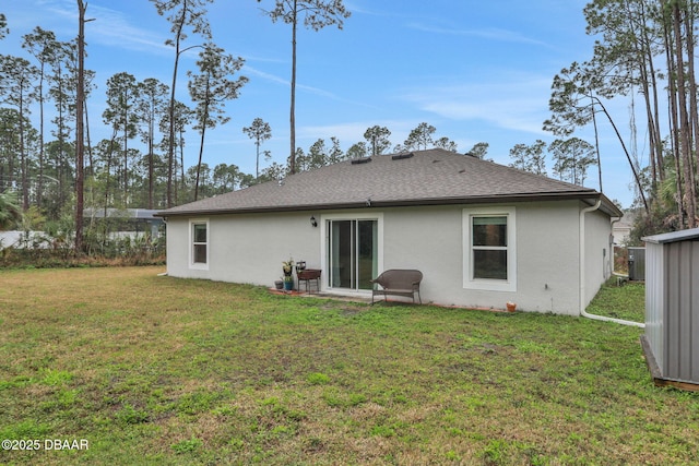 back of property featuring stucco siding, central AC unit, a lawn, and roof with shingles