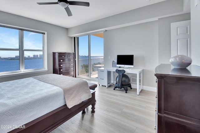 bedroom with access to outside, light hardwood / wood-style flooring, a water view, and ceiling fan