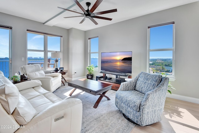 living room featuring a water view, ceiling fan, and light hardwood / wood-style flooring