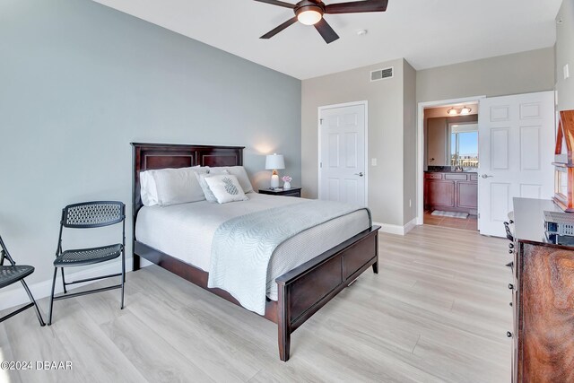 2801 S Ridgewood Ave Unit 608, South Daytona, FL 32119 - bedroom with light wood-style floors, baseboards, ensuite bath, ceiling fan, and a sink