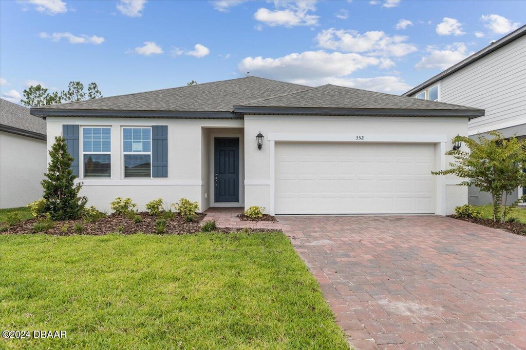 view of front of house featuring a garage and a front yard