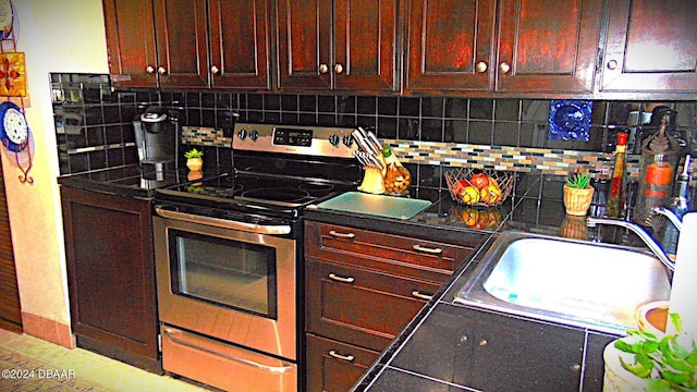 kitchen with tasteful backsplash, stainless steel electric stove, and sink