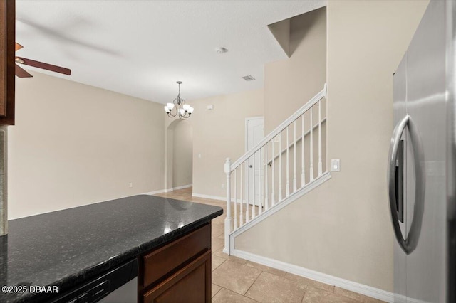 142 Aston Grande Dr, Daytona Beach, FL 32124 - kitchen featuring appliances with stainless steel finishes, a ceiling fan, arched walkways, a chandelier, and dark stone countertops