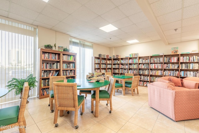 interior space featuring light tile patterned floors and a drop ceiling