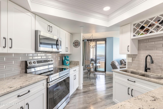 kitchen featuring white cabinetry, sink, appliances with stainless steel finishes, and tasteful backsplash