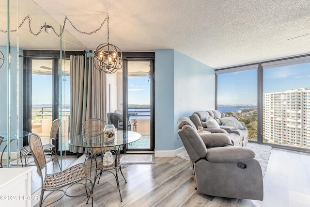 dining space featuring hardwood / wood-style flooring, floor to ceiling windows, a wealth of natural light, and a chandelier