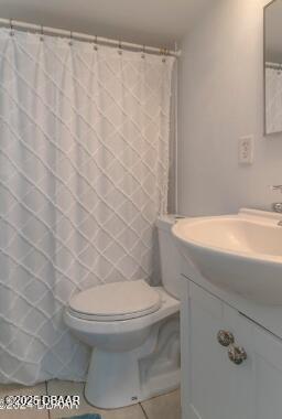full bathroom featuring toilet, vanity, and tile patterned floors