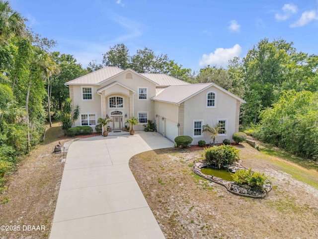 2710 Quiet Ln, Cocoa, FL 32926 - view of front facade with a garage, stucco siding, driveway, and metal roof