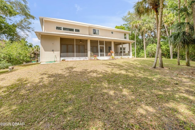 2710 Quiet Ln, Cocoa, FL 32926 - rear view of house featuring a sunroom, ceiling fan, a lawn, and stucco siding