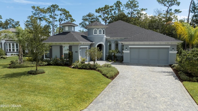 view of front of home with a garage and a front lawn