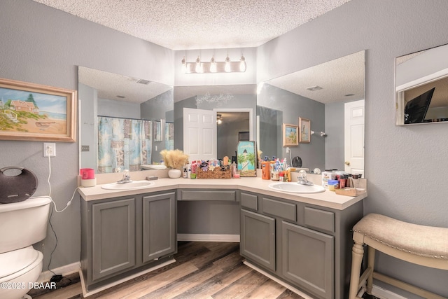 bathroom featuring curtained shower, a textured ceiling, toilet, and vanity