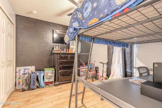 bedroom featuring hardwood / wood-style flooring, a textured ceiling, and a closet