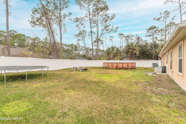 view of yard featuring a swimming pool and a trampoline