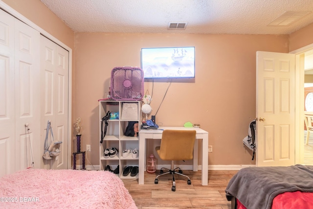 bedroom featuring a textured ceiling, a closet, and light wood-type flooring