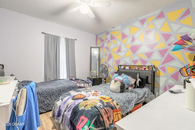 bedroom featuring light hardwood / wood-style floors, a textured ceiling, and ceiling fan