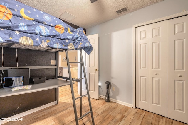 unfurnished bedroom with a closet, hardwood / wood-style flooring, and a textured ceiling