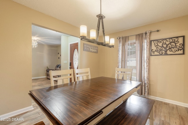 dining area featuring a textured ceiling and light hardwood / wood-style flooring