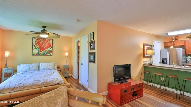1401 S Palmetto Ave Unit 402, Daytona Beach, FL 32114 - bedroom with stainless steel fridge with ice dispenser, wood finished floors, and a textured ceiling