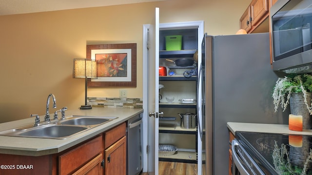 1401 S Palmetto Ave Unit 402, Daytona Beach, FL 32114 - kitchen featuring stainless steel appliances, wood finished floors, light countertops, a peninsula, and brown cabinetry
