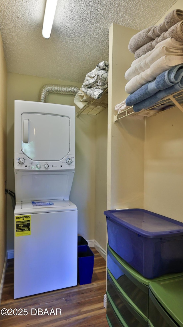1401 S Palmetto Ave Unit 402, Daytona Beach, FL 32114 - laundry area featuring stacked washing machine and dryer, wood finished floors, and a textured ceiling