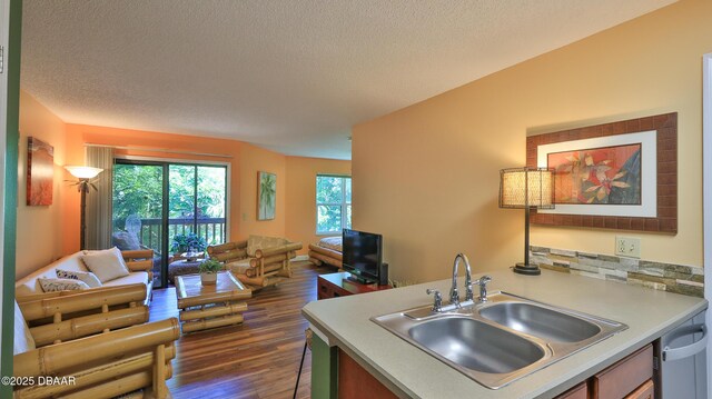 1401 S Palmetto Ave Unit 402, Daytona Beach, FL 32114 - kitchen featuring open floor plan, dark wood-style flooring, light countertops, dishwasher, and a textured ceiling