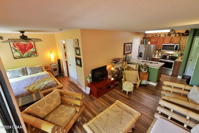 living room featuring a textured ceiling, dark hardwood / wood-style floors, and ceiling fan