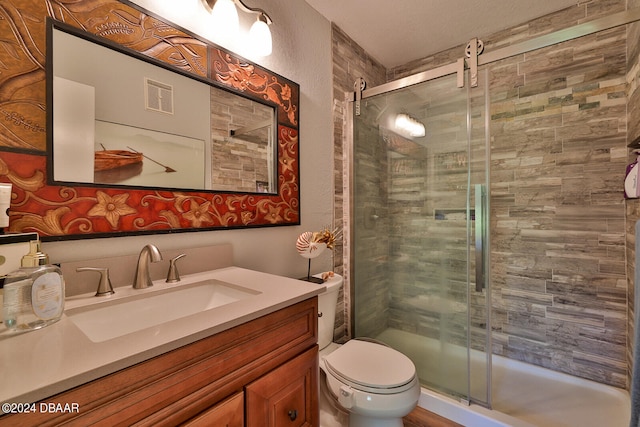 bathroom featuring toilet, an enclosed shower, vanity, and a textured ceiling