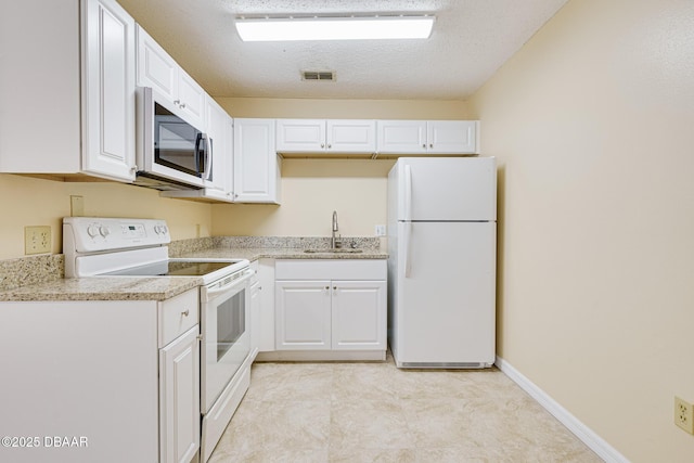 kitchen featuring a sink, a textured ceiling, white appliances, white cabinets, and visible vents