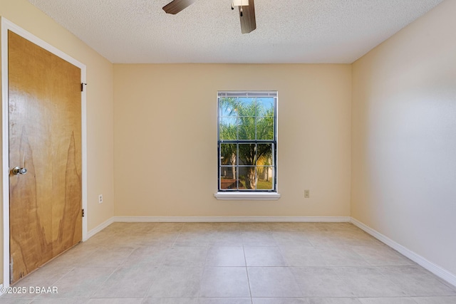 unfurnished room featuring a textured ceiling, baseboards, ceiling fan, and light tile patterned floors