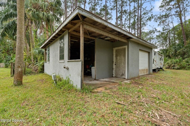 view of outdoor structure featuring a lawn and a garage