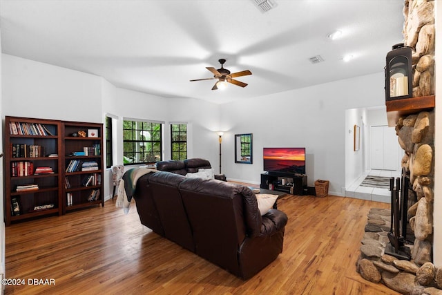 living room with a fireplace, light hardwood / wood-style flooring, and ceiling fan