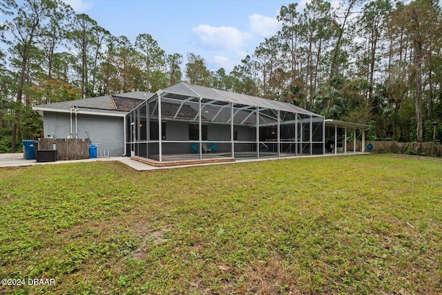 rear view of house with a lawn and glass enclosure