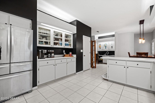 kitchen with stainless steel refrigerator with ice dispenser, white cabinetry, hanging light fixtures, and light tile patterned flooring