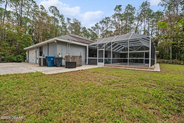 rear view of house with a lawn, glass enclosure, and central air condition unit