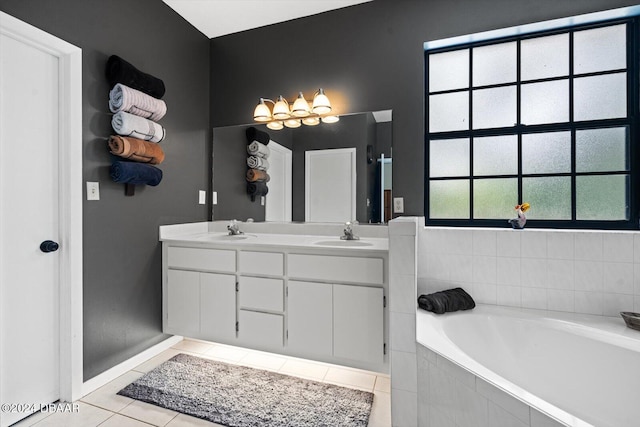 bathroom with tile patterned floors, vanity, and a relaxing tiled tub