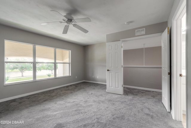 unfurnished bedroom with multiple windows, carpet floors, and ceiling fan