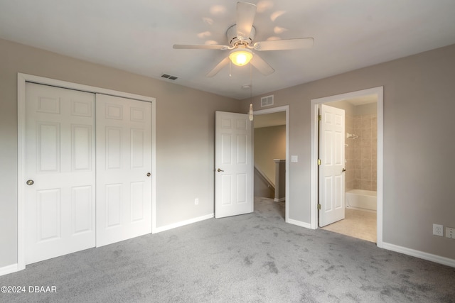 unfurnished bedroom with ensuite bath, ceiling fan, light colored carpet, and a closet