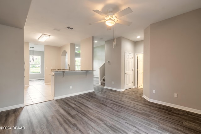 unfurnished living room featuring hardwood / wood-style flooring and ceiling fan