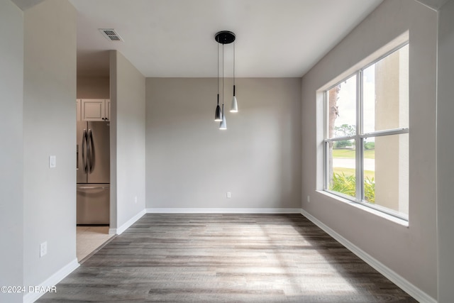 unfurnished dining area with wood-type flooring and plenty of natural light