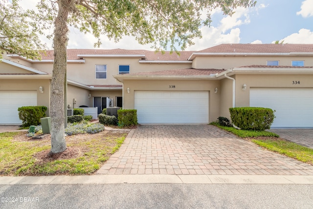 view of front of property featuring a garage and central AC