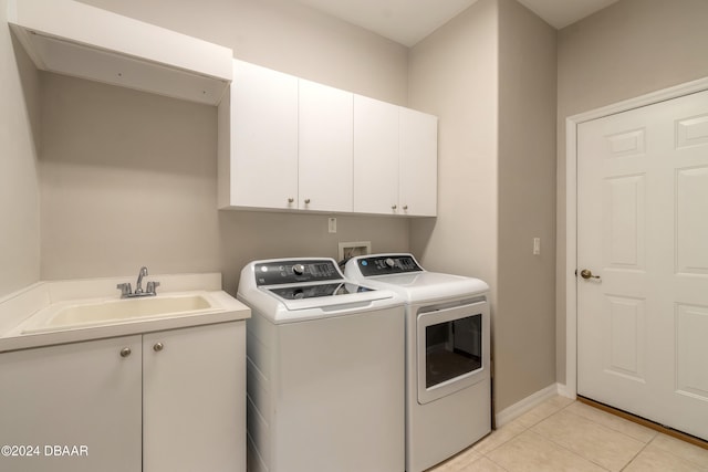 washroom with washing machine and dryer, cabinets, sink, and light tile patterned flooring