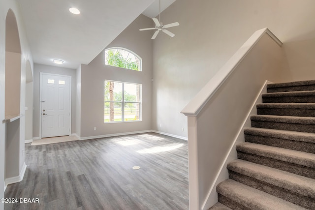 foyer entrance with high vaulted ceiling, wood-type flooring, and ceiling fan