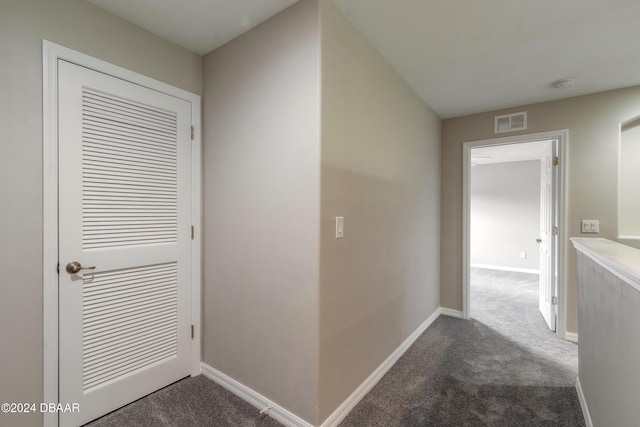 hall featuring dark colored carpet