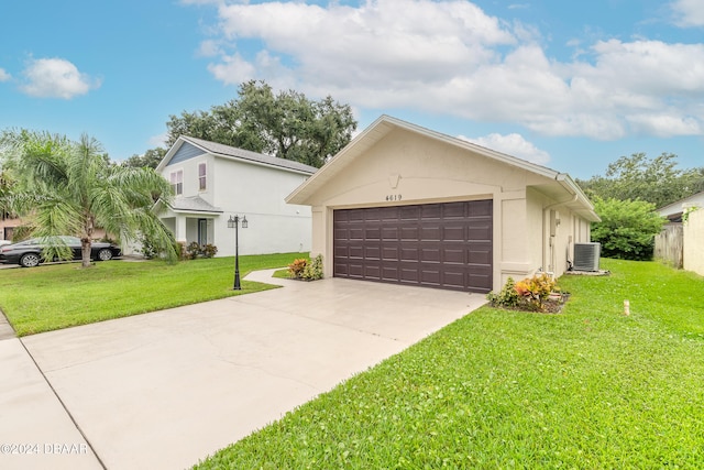 view of front of house with a front lawn, a garage, and central AC