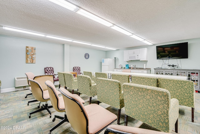 carpeted dining area with a textured ceiling and sink