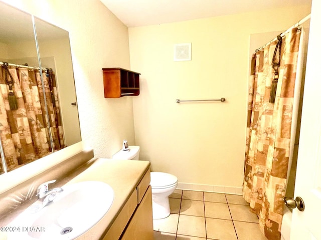 bathroom featuring toilet, walk in shower, vanity, and tile patterned floors