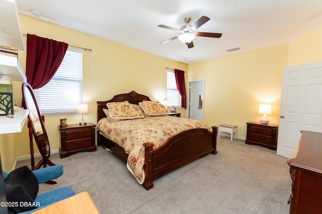 bedroom featuring a ceiling fan, baseboards, visible vents, and light carpet