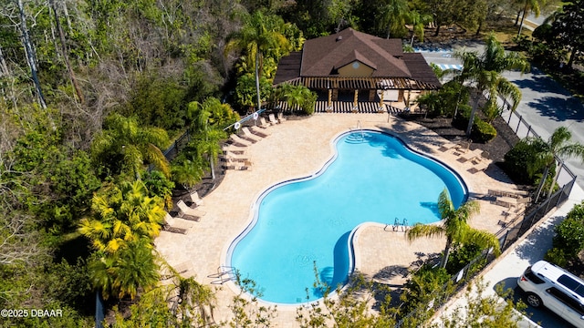 community pool with a patio and fence