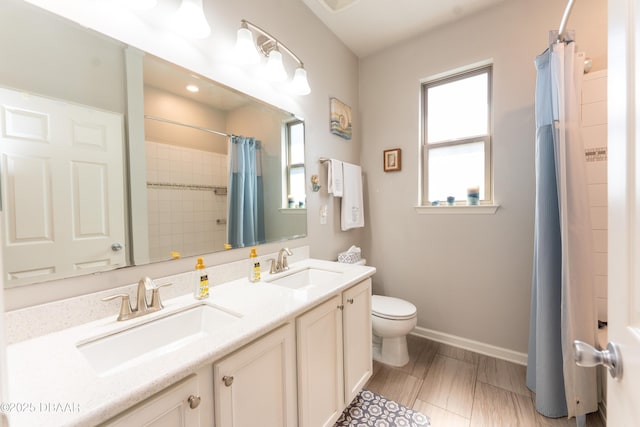 full bathroom with a sink, baseboards, toilet, and a shower with shower curtain