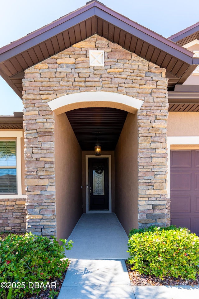 property entrance with stone siding and stucco siding